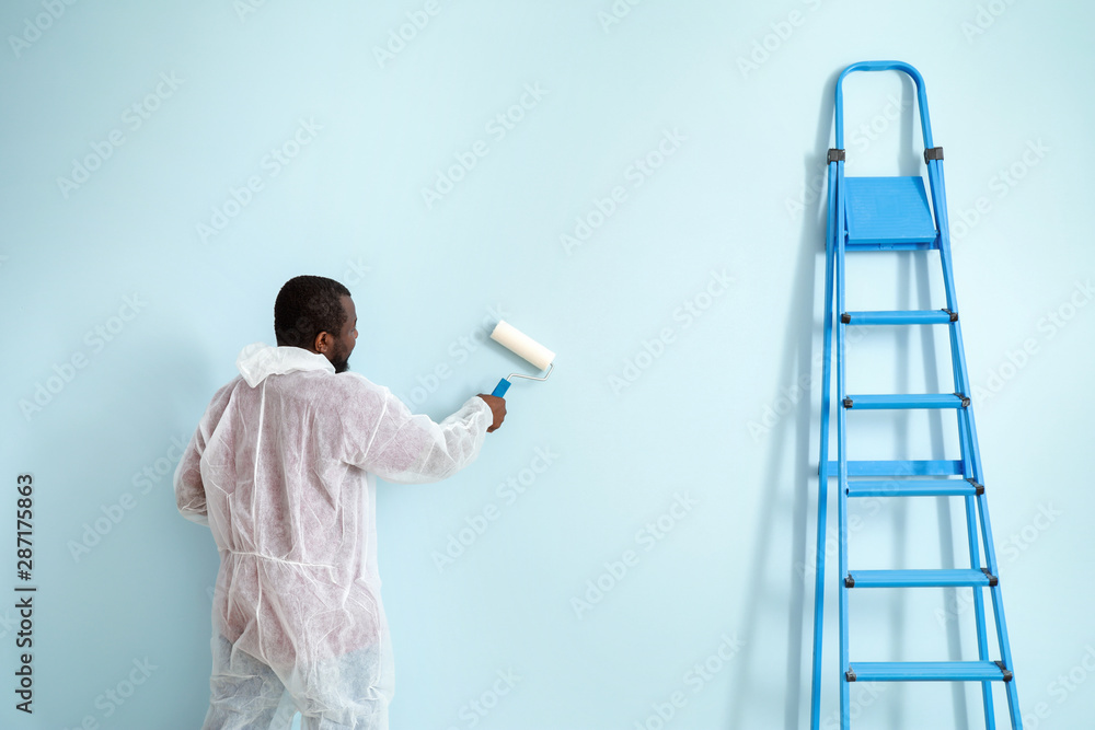 African-American decorator painting wall