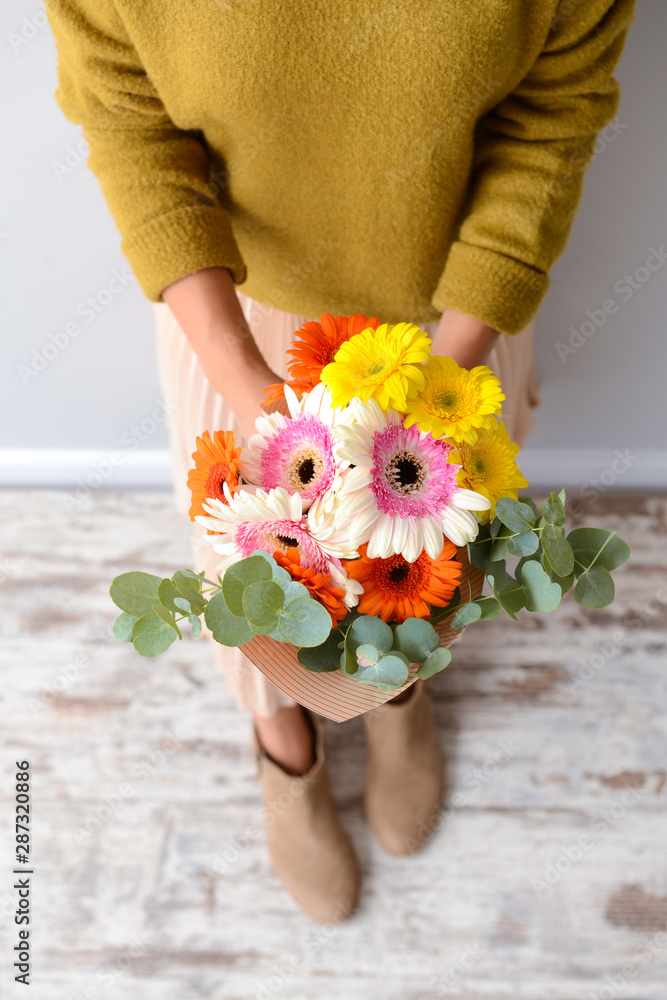 室内有一束美丽的非洲菊花的女人