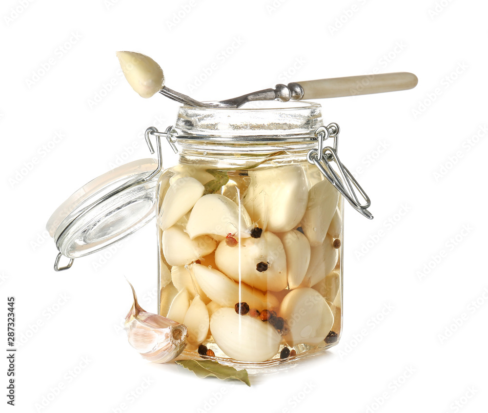 Jar with canned garlic on white background