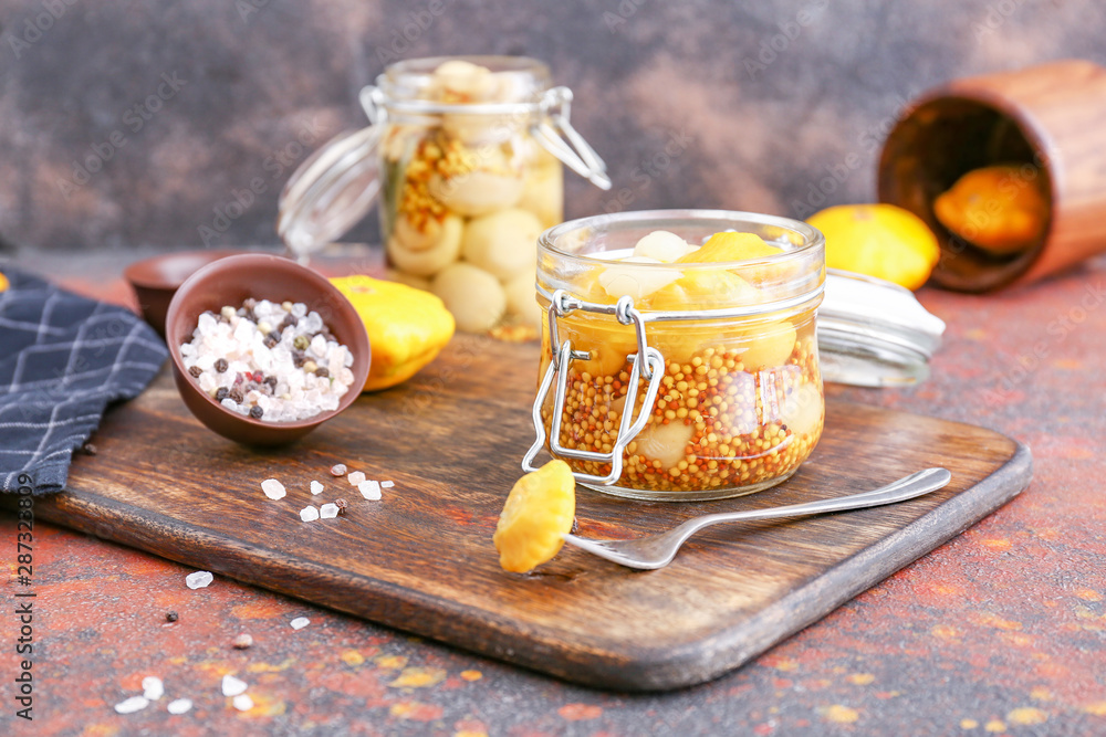 Jar with canned squashes on table