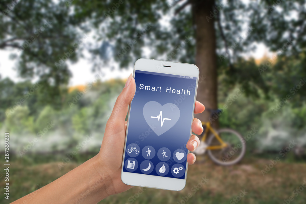 Health monitoring concept - special app on smartphone in a hand outdoors, landscape background