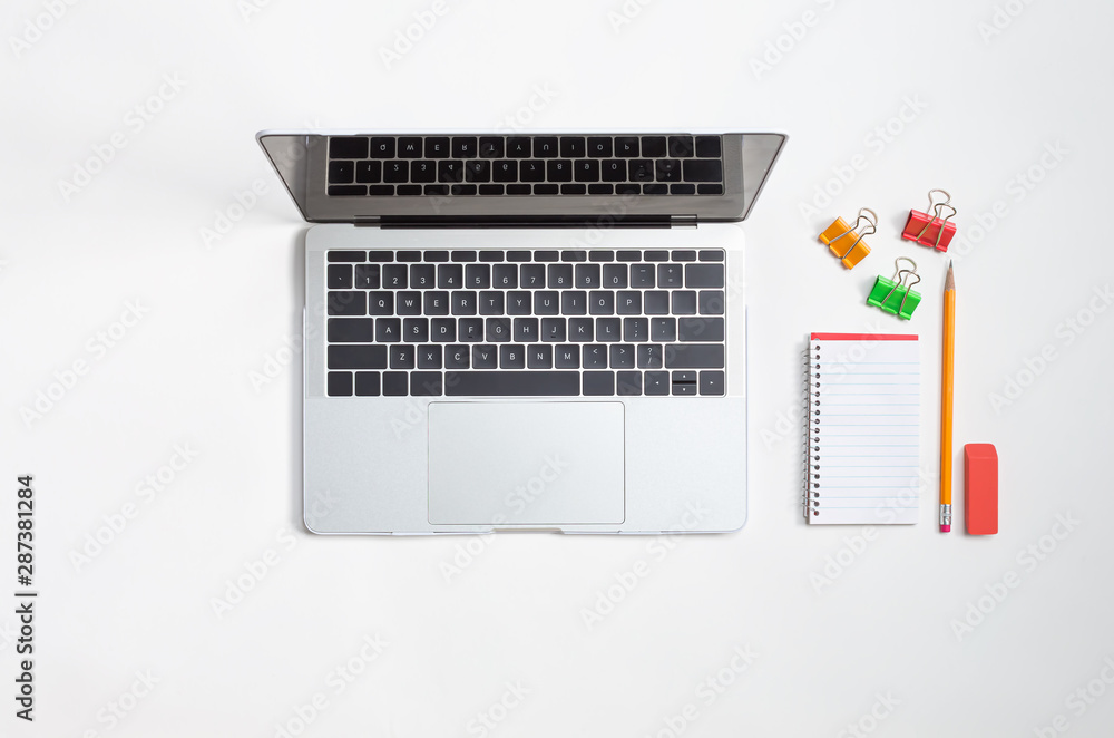 Laptop computer with school supplies from above