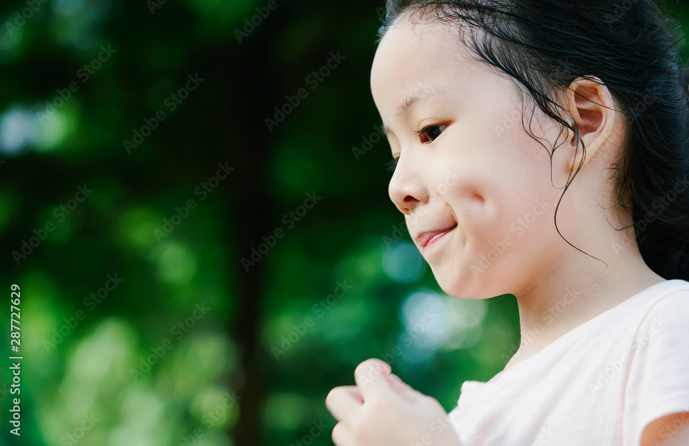 Close Up portrait of little asian girl with dimples in park