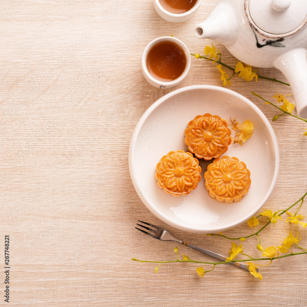 中秋节月饼、月饼、茶具在明亮的木桌上的概念设计w