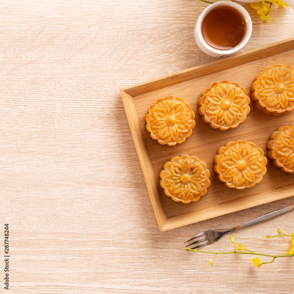 中秋节月饼、月饼、茶具在明亮的木桌上的概念设计w