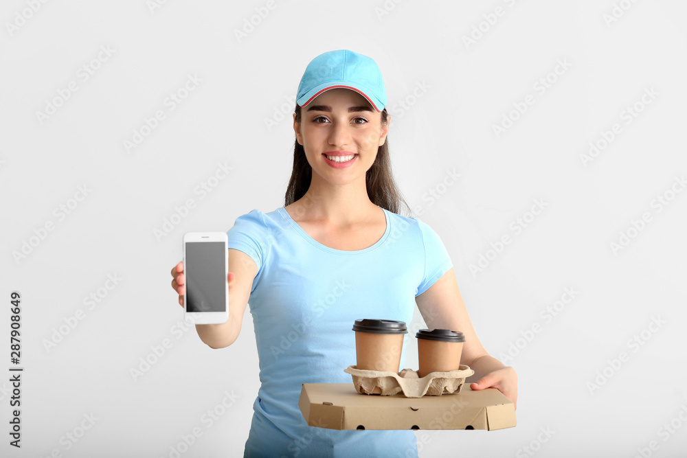 Female worker of food delivery service with mobile phone on white background