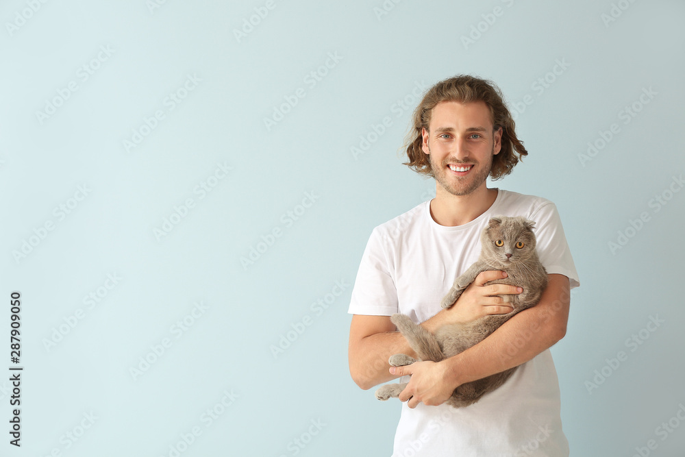 Man with cute funny cat on light background