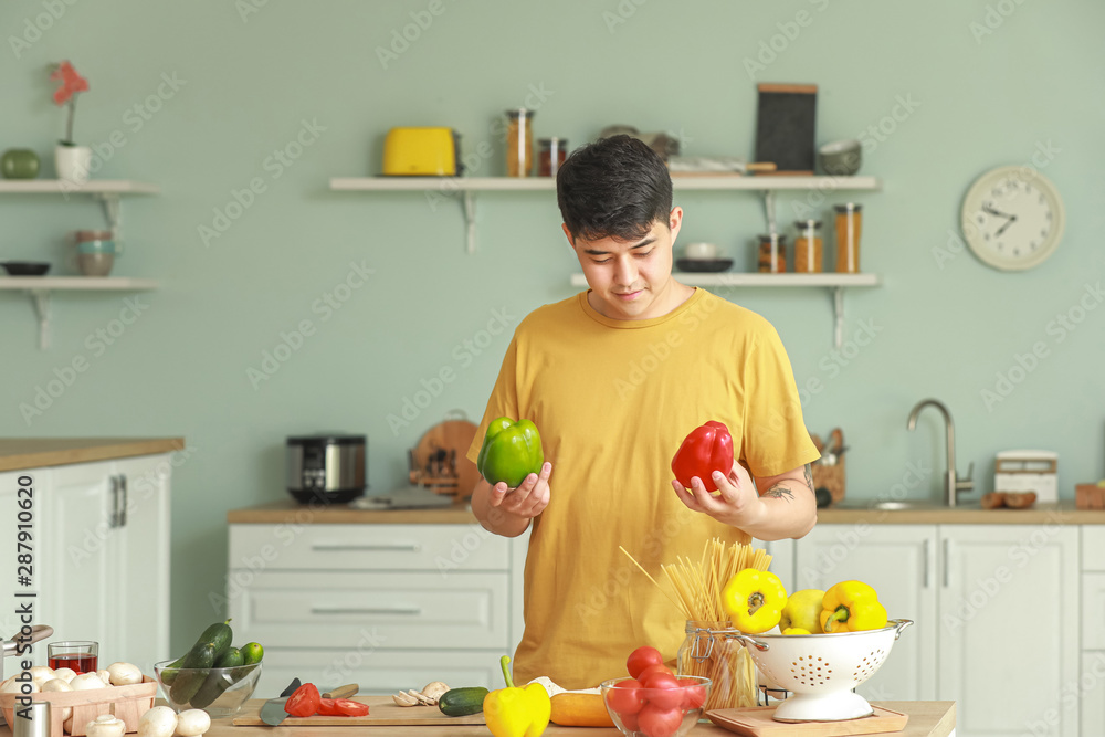 英俊的亚洲男人在厨房做饭