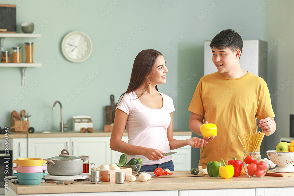 Happy couple cooking together in kitchen