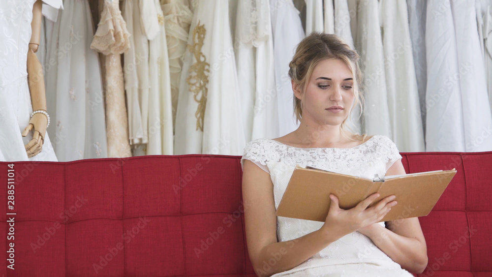 Bride reading book or catalogue in wedding studio choosing the wedding ceremony package service.