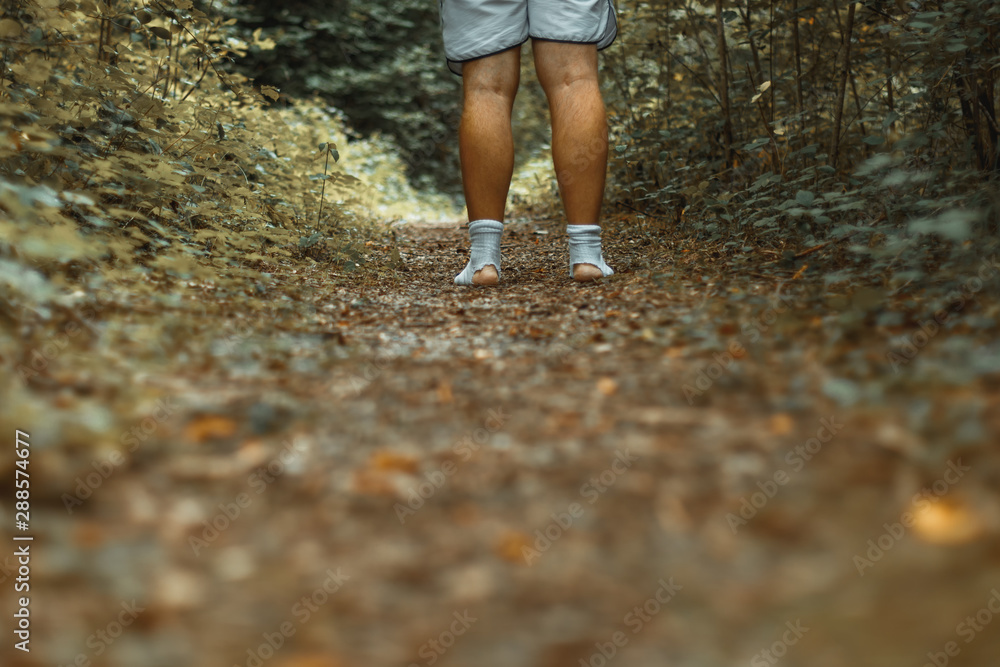 Stehen bleiben auf einem Waldweg mit zerrissenen Socken