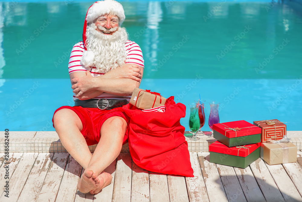 Santa Claus with gifts near swimming pool at resort