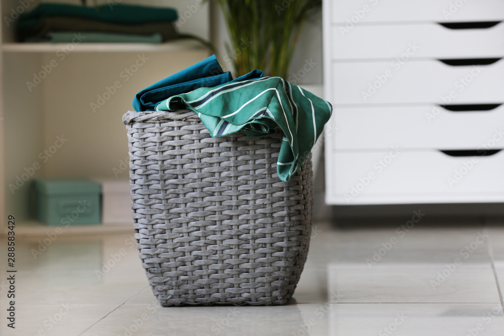 Basket with laundry on floor in room