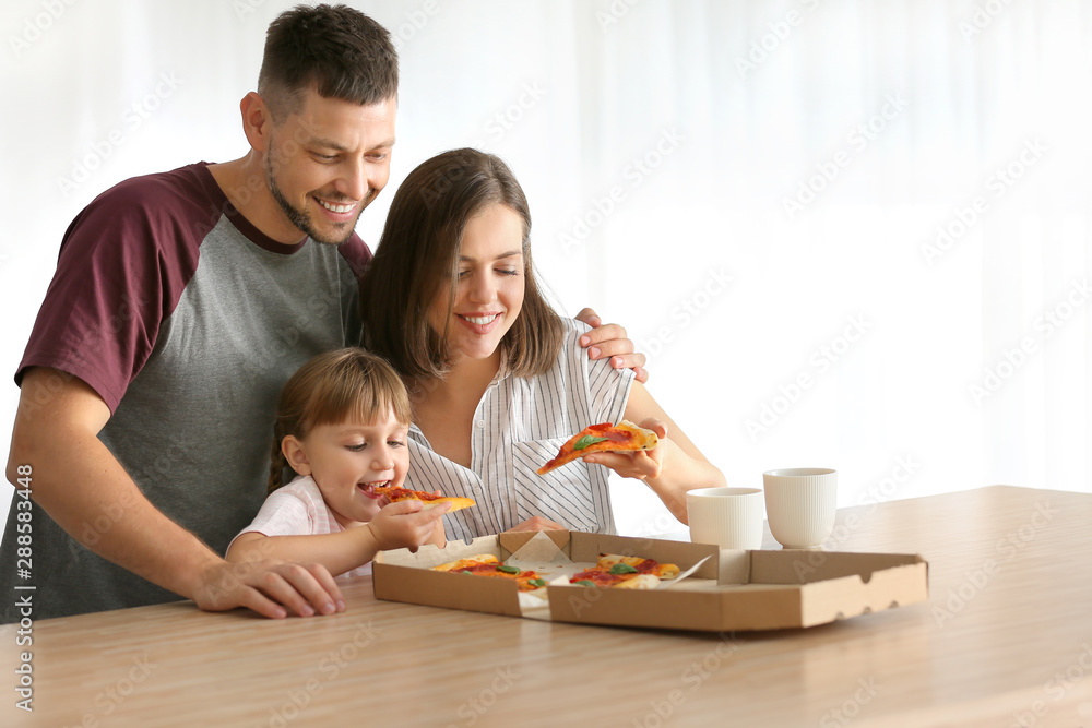 Happy family eating pizza at home