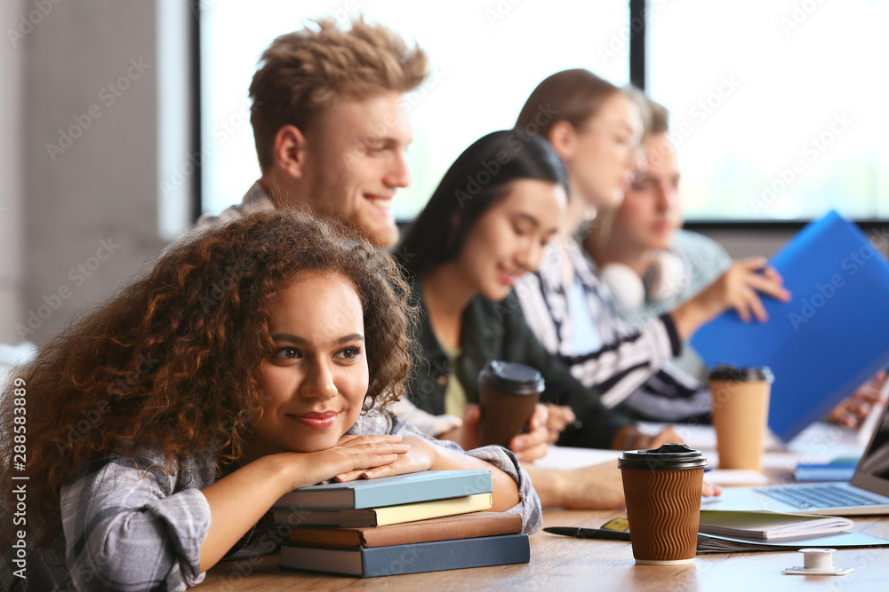 African-American student with fellows sitting in reading room