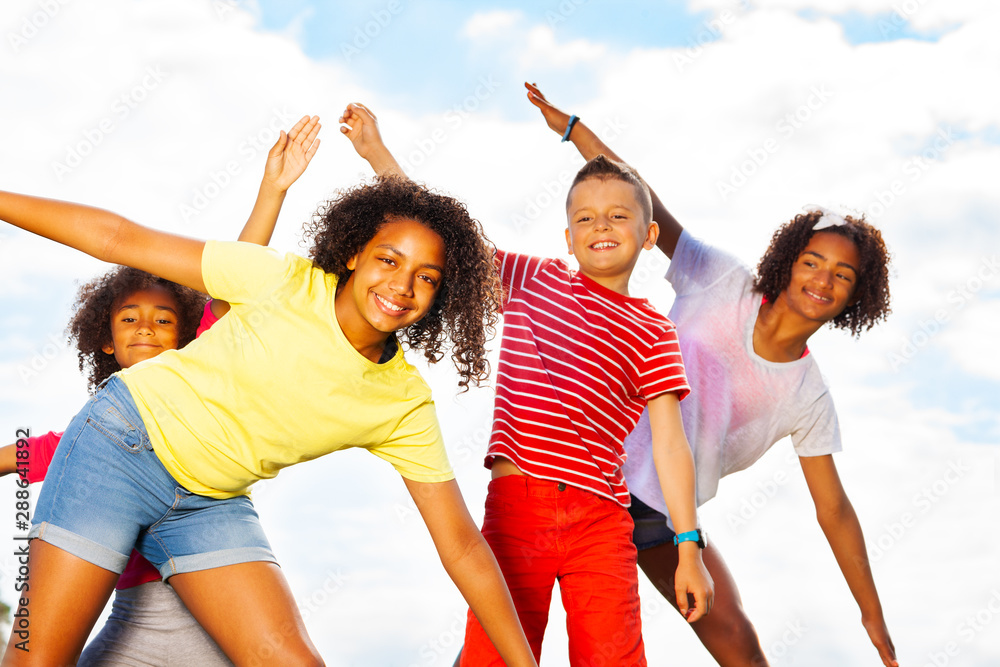 Group of kids smile bending, leaning together