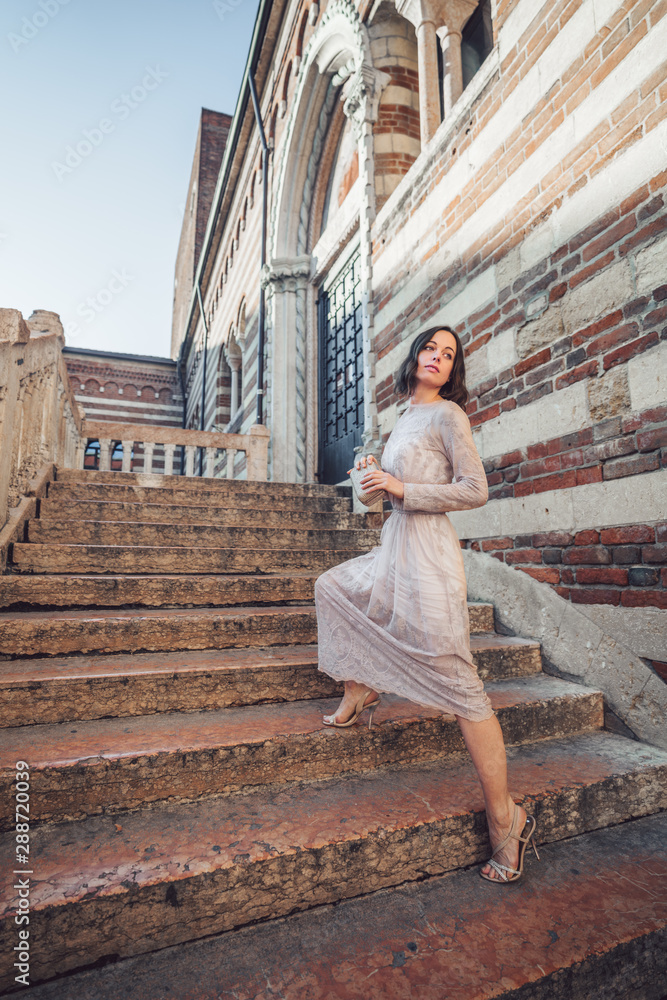 Young girl in a beautiful dress on the stairs