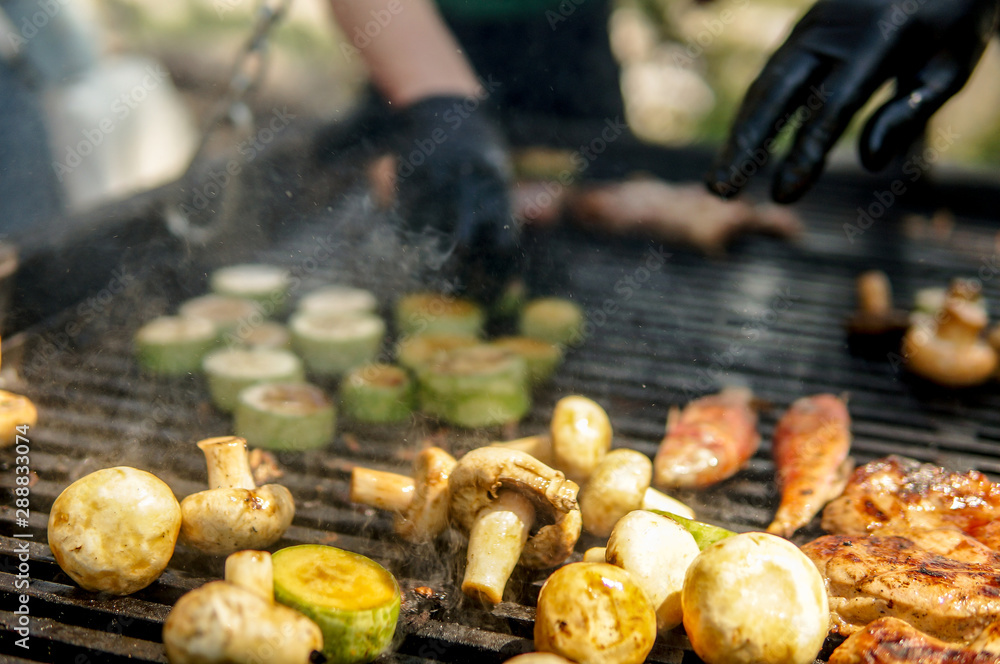 Meat with vegetables grilling over coals outdoors while celebration holiday