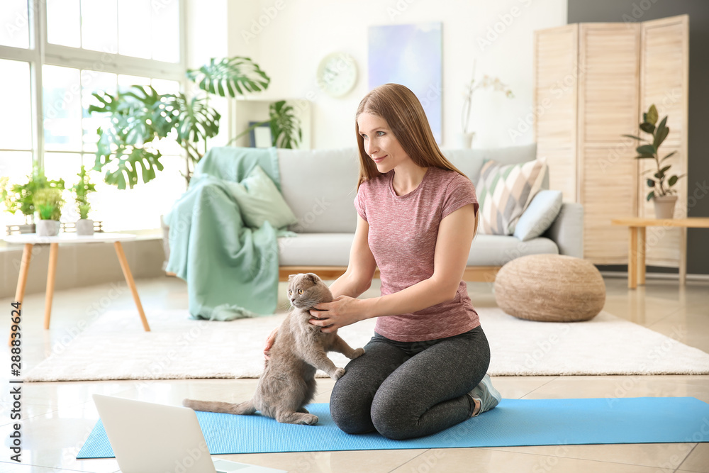 Beautiful woman with cute cat at home