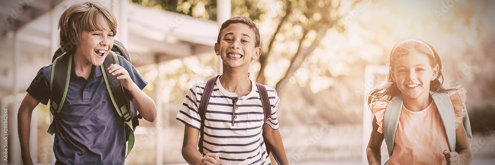 Happy school kids running in corridor