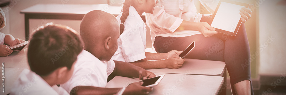 Teacher teaching kids on digital tablet