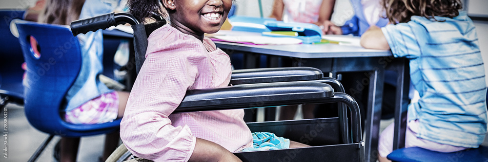 Disabled schoolgirl smiling in classroom