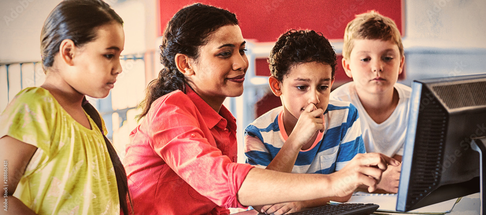 Female teacher teaching computer to children 