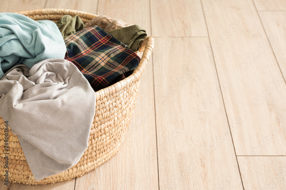 Basket with dirty laundry on floor