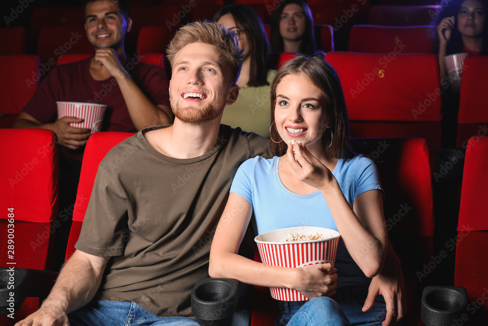 Couple with popcorn watching movie in cinema