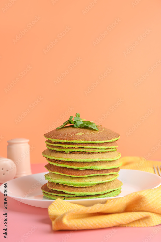 Tasty green pancakes on table