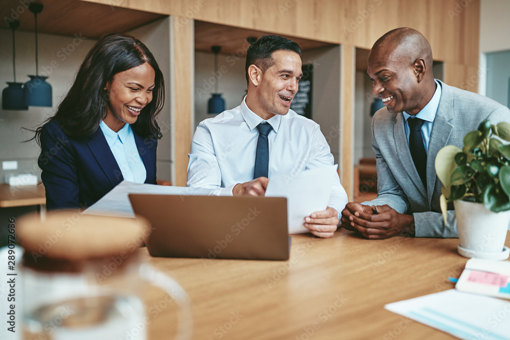 Diverse businesspeople smiling while working together at an offi