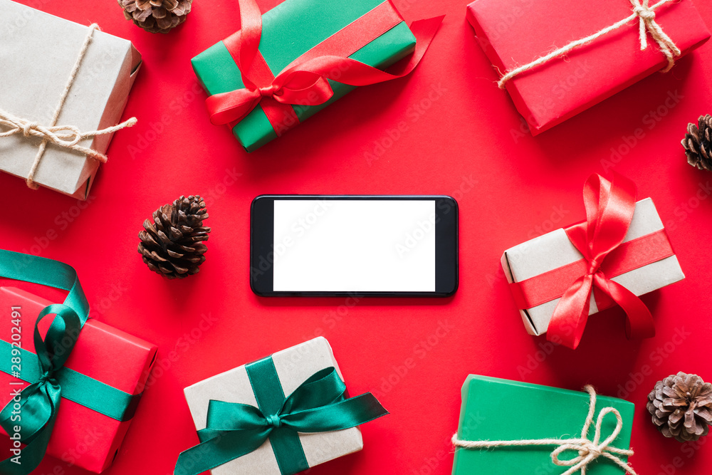 Mobile phone with gift/presents box over red background for chirstmas and happy new year concept. to