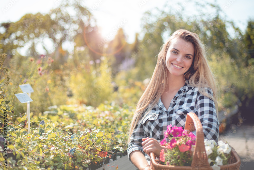 Customer with basket full of flowers in garden center