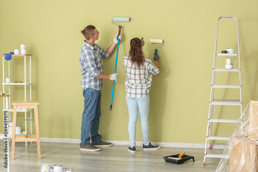 Happy young couple doing repair in their new house