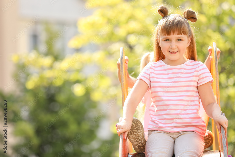 Cute little girl sliding on playground