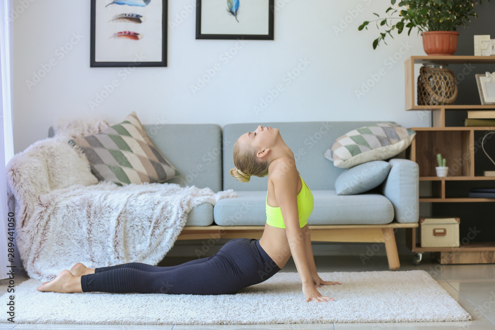 Young woman practicing yoga at home