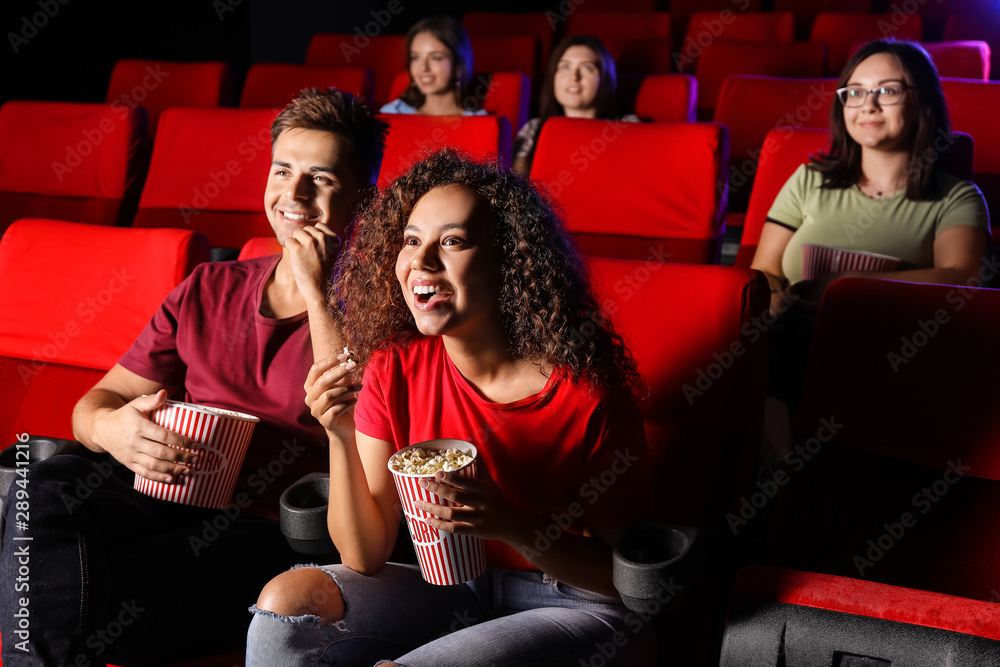 Couple with popcorn watching movie in cinema