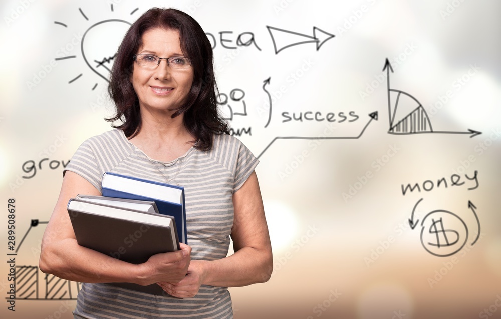 Mature woman teacher with books on background