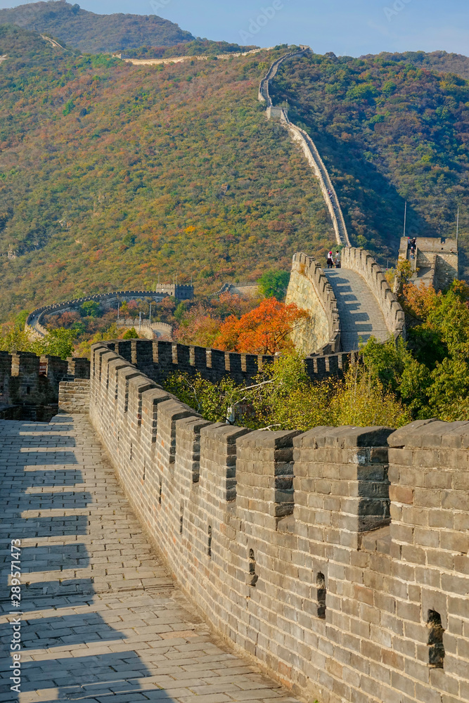 垂直：石墙穿过秋色山脉的景色。