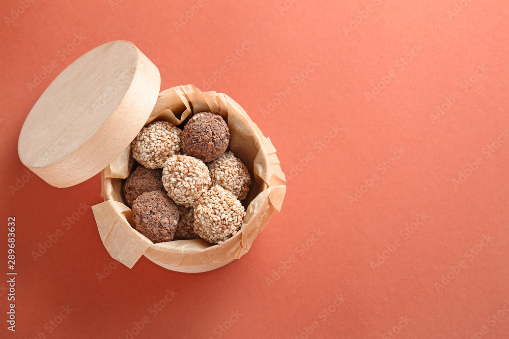 Box with tasty sweet truffles on color background