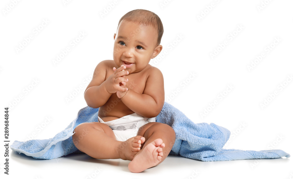 Cute African-American baby with soft towel on white background