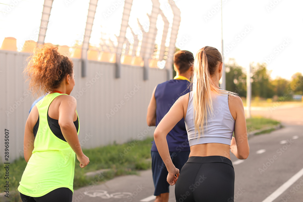 Group of sporty young people running outdoors