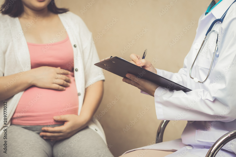 Happy pregnant woman visit gynecologist doctor at hospital or medical clinic for pregnancy consultan