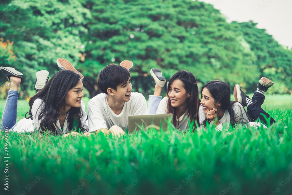 在大学或学校公园的小组项目中学习的年轻学生团队。学习快乐