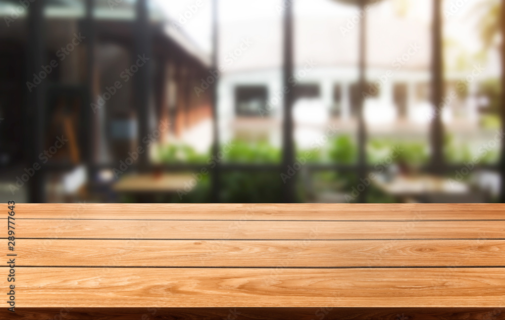 Wood table in blurry background of modern restaurant room or coffee shop with empty copy space on th