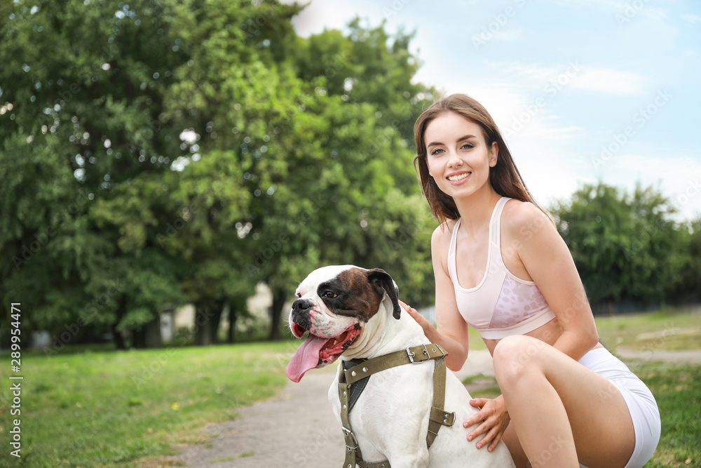 Sporty young woman with cute dog in park