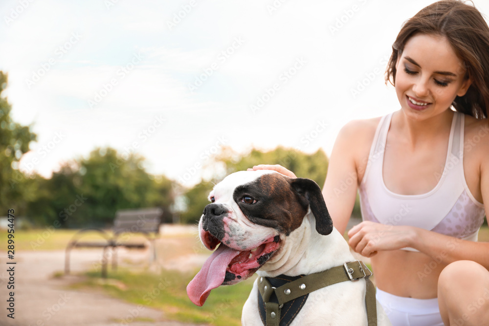 Sporty young woman with cute dog in park