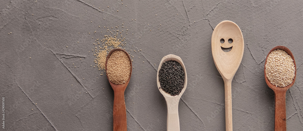 Superfood in spoons over gray concrete background