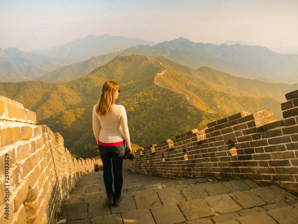 Young female photographer observes the woods surrounding the Great Wall of China