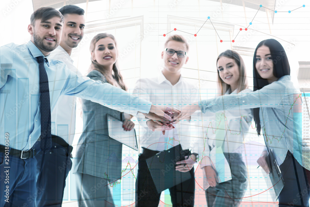 Group of business people putting hands together in office